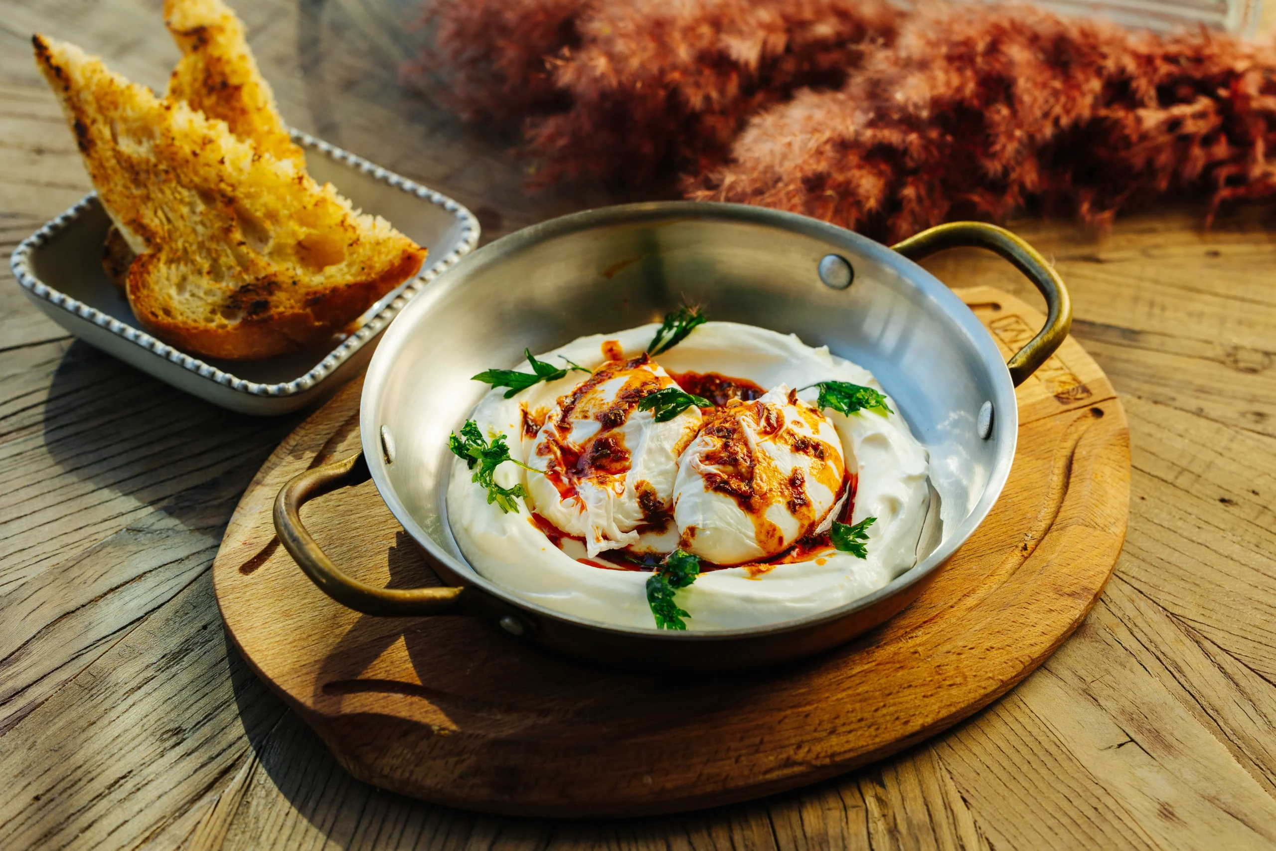 A bowl with food with toast on the side 